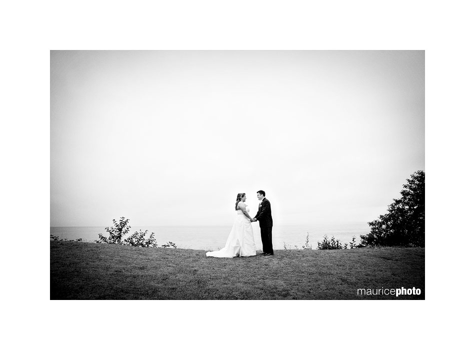 A black and white picture of a bride and groom in the rain. 
